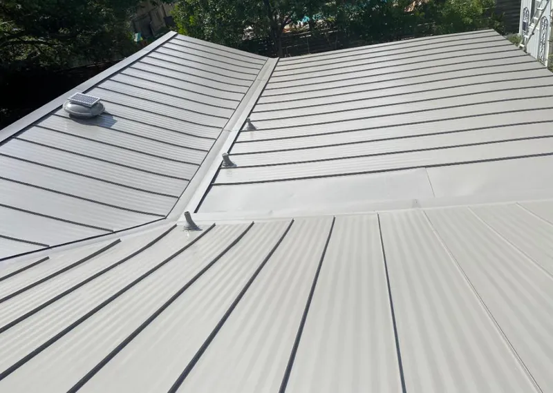Solar attic fan installed on a metal roof for Roof Ventilation in Huntington