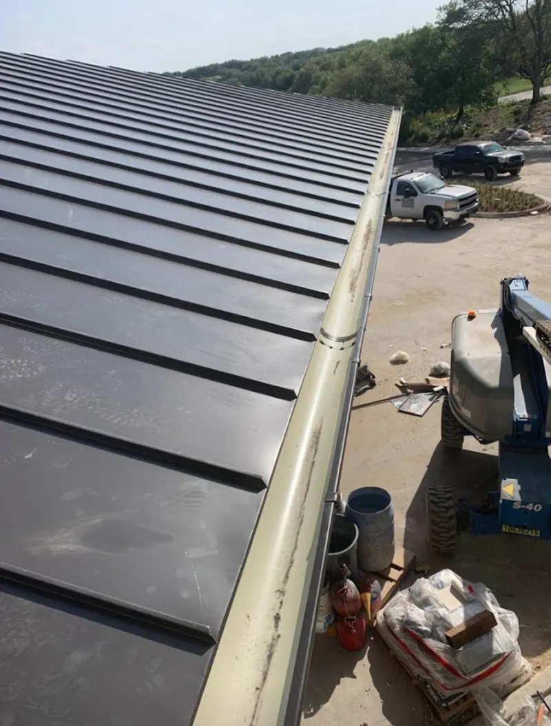 Standing seam panel and gutter detail on a metal roofing jobsite in Huntington